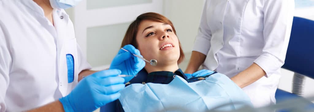 Dentist and His Assistant Inspecting Patient Teeth — Your Holistic Dentists in Casuarina, NSW