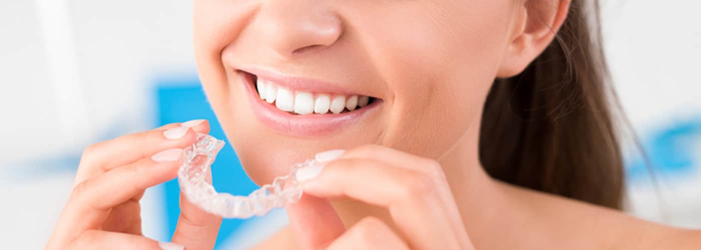 Woman Holding Invisalign Brace — Your Holistic Dentists in Casuarina, NSW