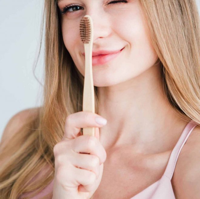 Pretty Girl holding Bamboo Toothbrush — Your Holistic Dentists in Casuarina, NSW